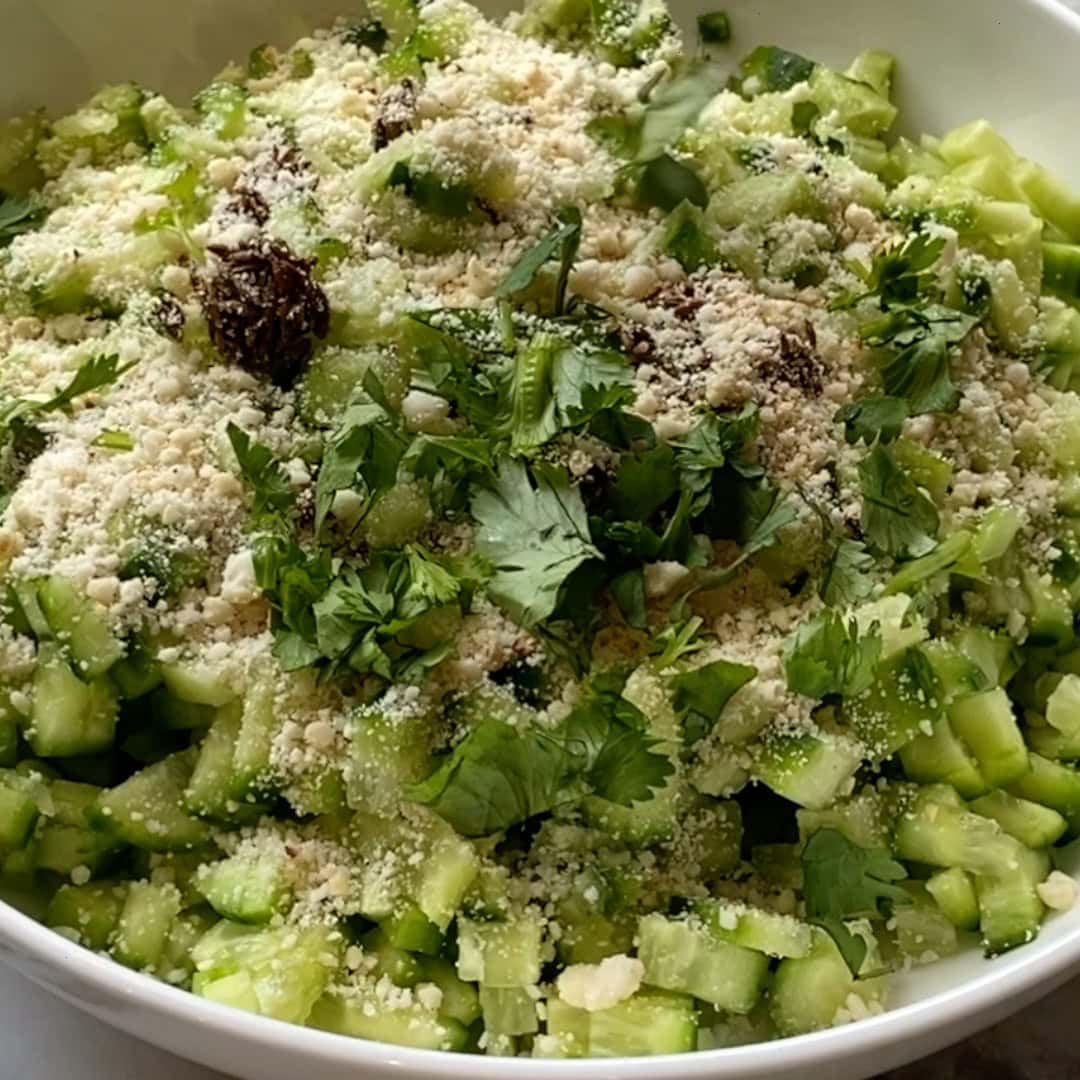 crushed peanuts and cilantro added to diced cucumbers.
