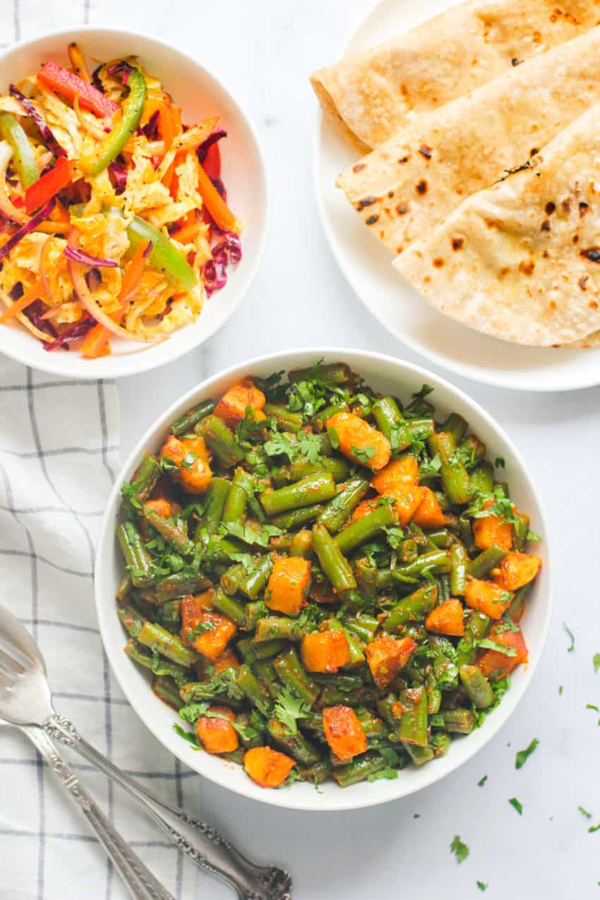 green bean curry with potatoes served with roti and cabbage salad 