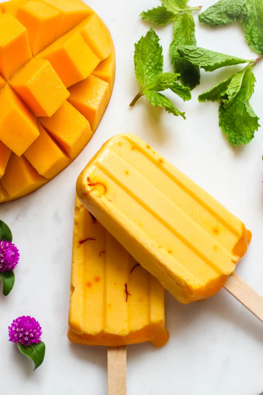 two popsicles stacked with cubed mango on the side