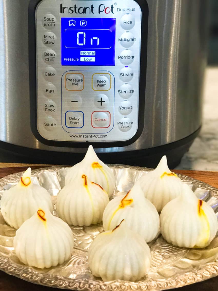 Ukadiche Modak in a silver platter placed in front of Instant Pot 