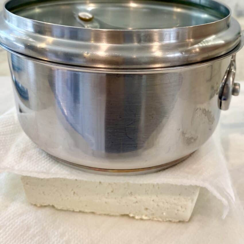 pressing tofu under a heavy pot 