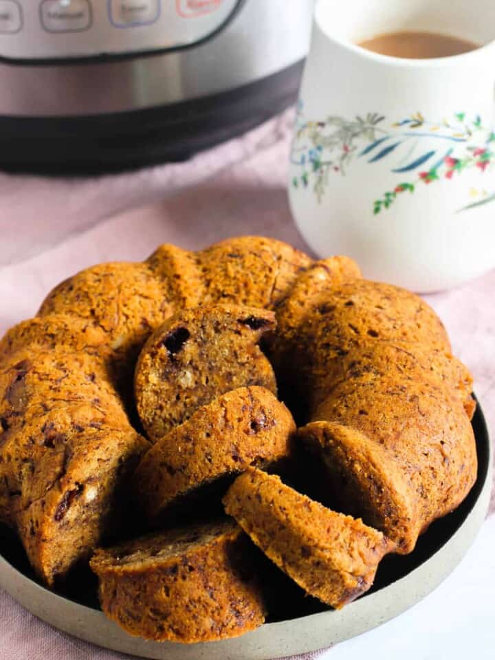 banana bread in a plate next to a cup of tea and Instant Pot a