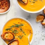 butternut squash soup served in 2 white bowls