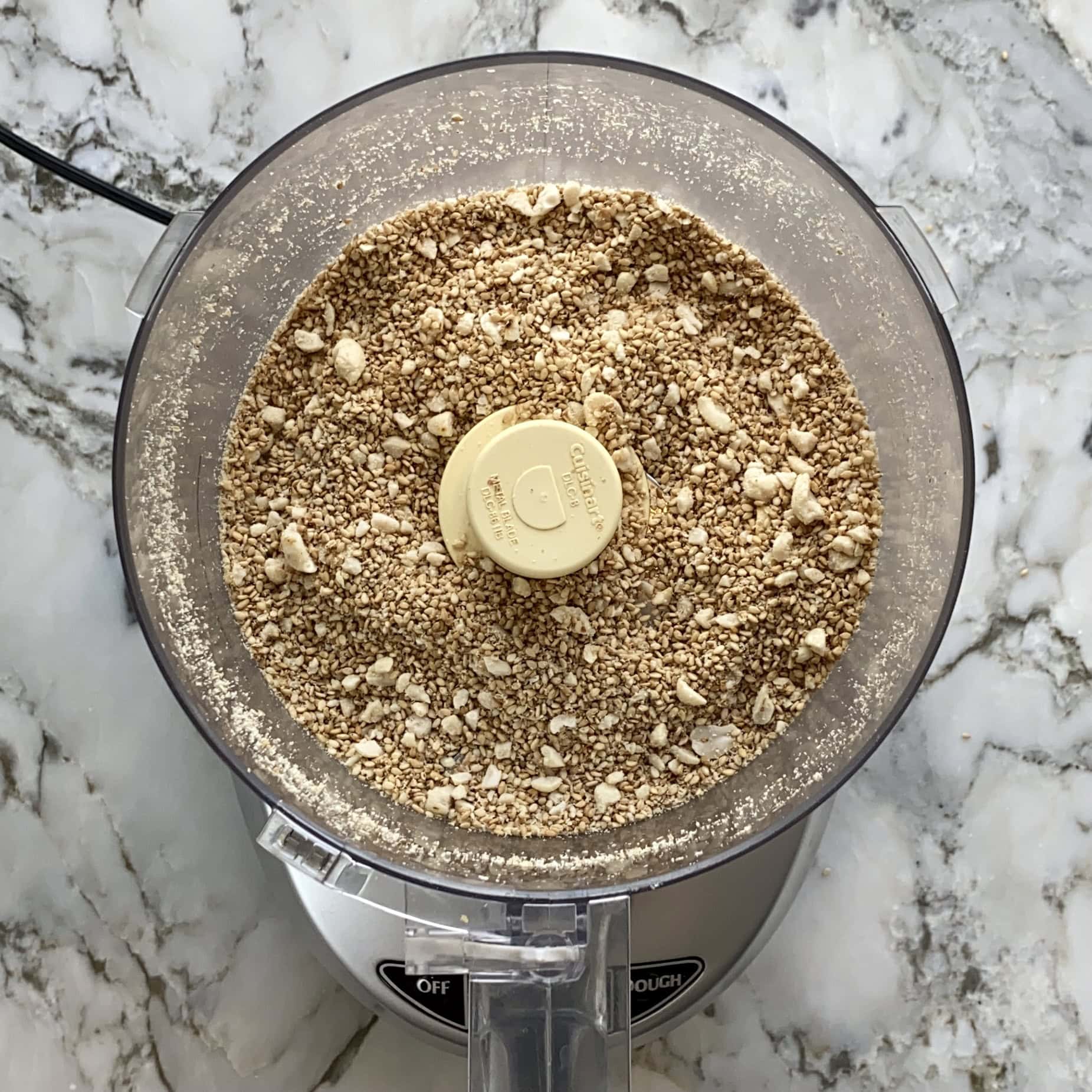 coarsely ground sesame seeds and peanuts in a food processor jar. 