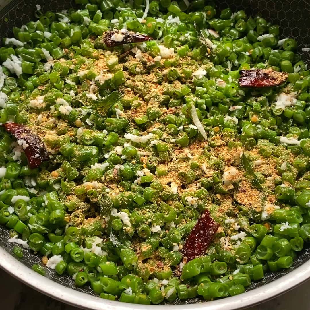 green beans poriyal garnished with coconut and podi.