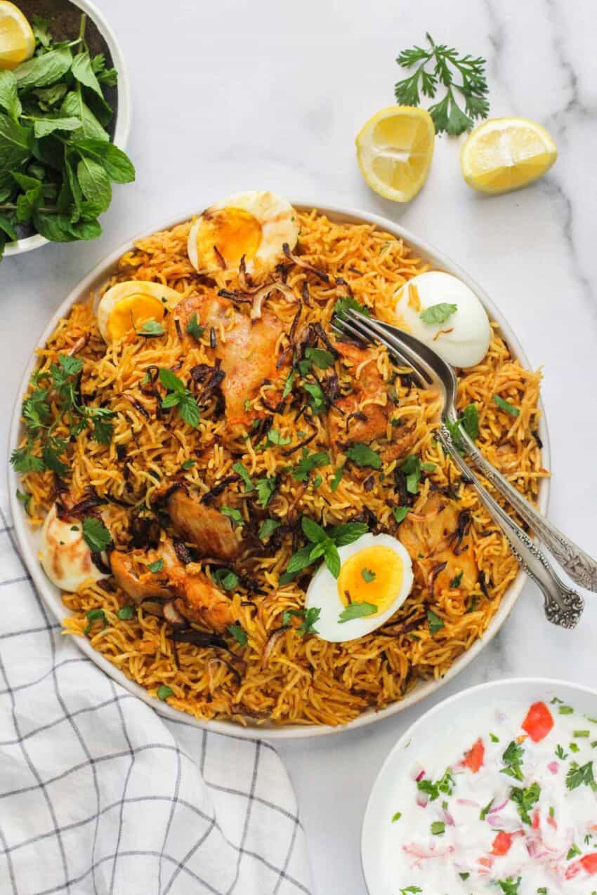 chicken biryani in a platter with hard boiled eggs on top