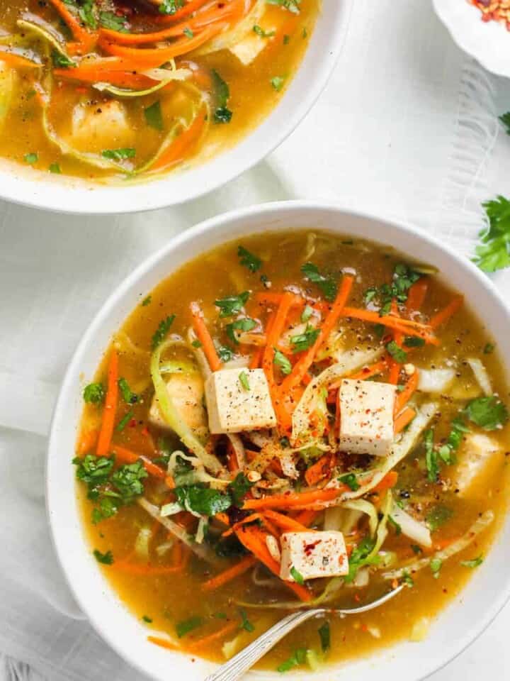 lemon coriander soup with tofu served in a white bowl