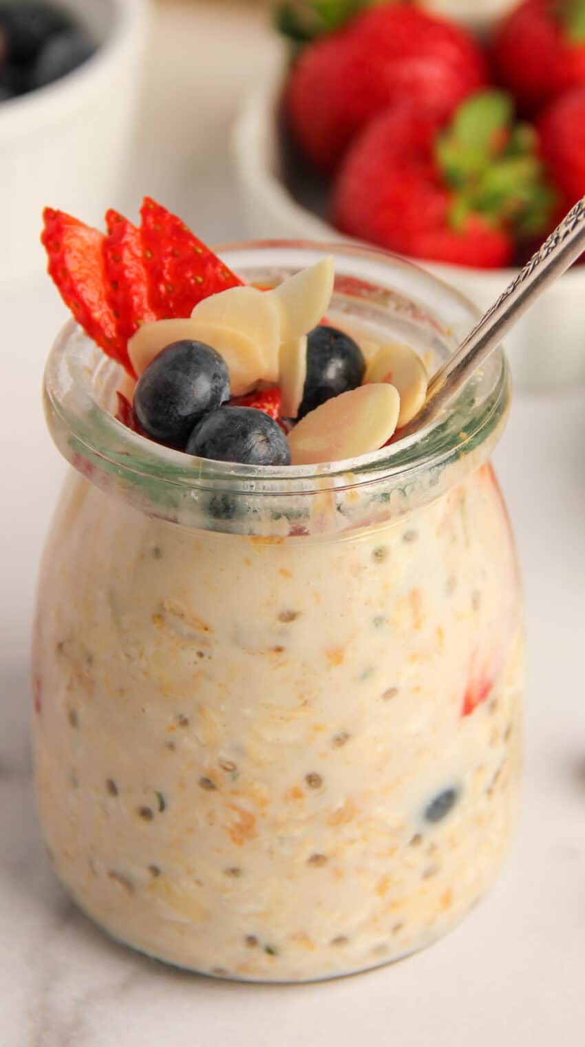 a jar of overnight oats with chia seeds, topped with berries and almonds