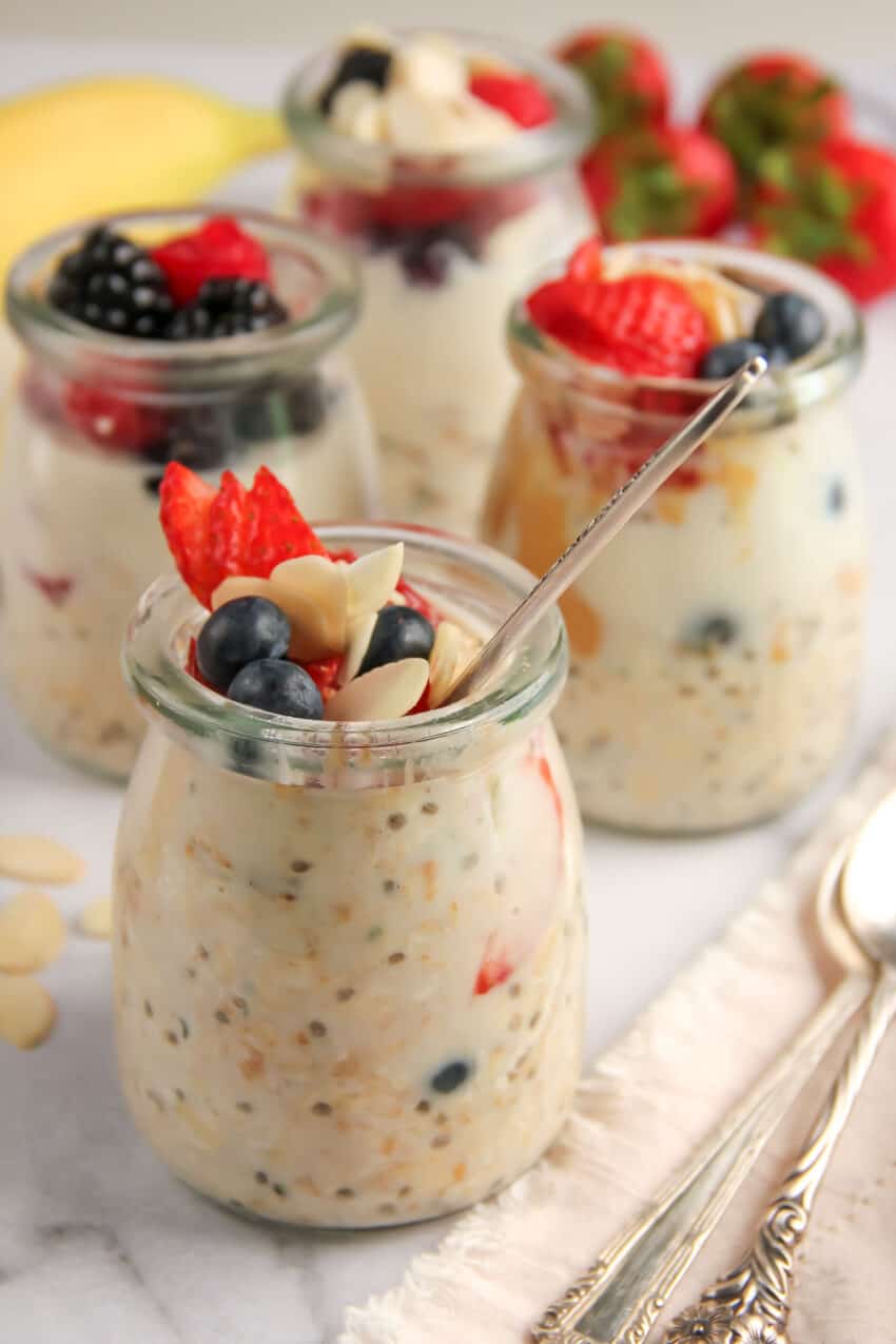 Overnight oats with chia seeds in small glass jars topped with berries and almonds