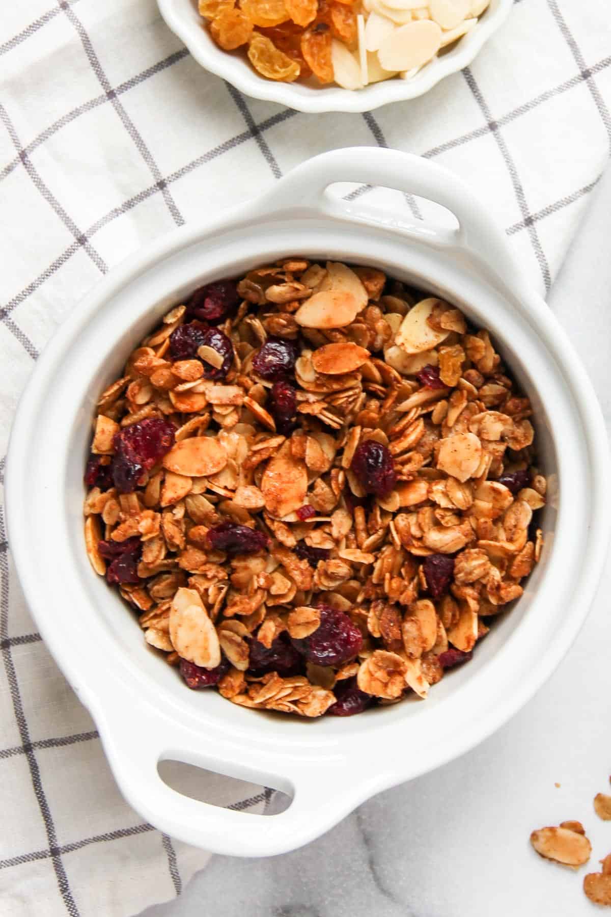 homemade granola with dried cranberries and raisins in a white bowl 