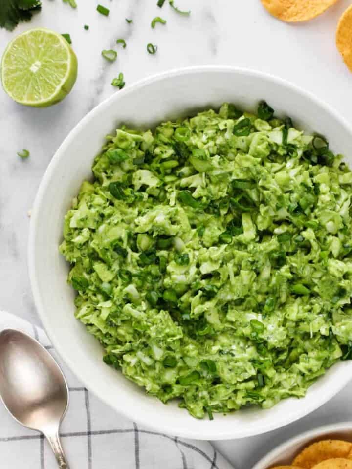 green goddess salad served in a white bowl with tortilla chips