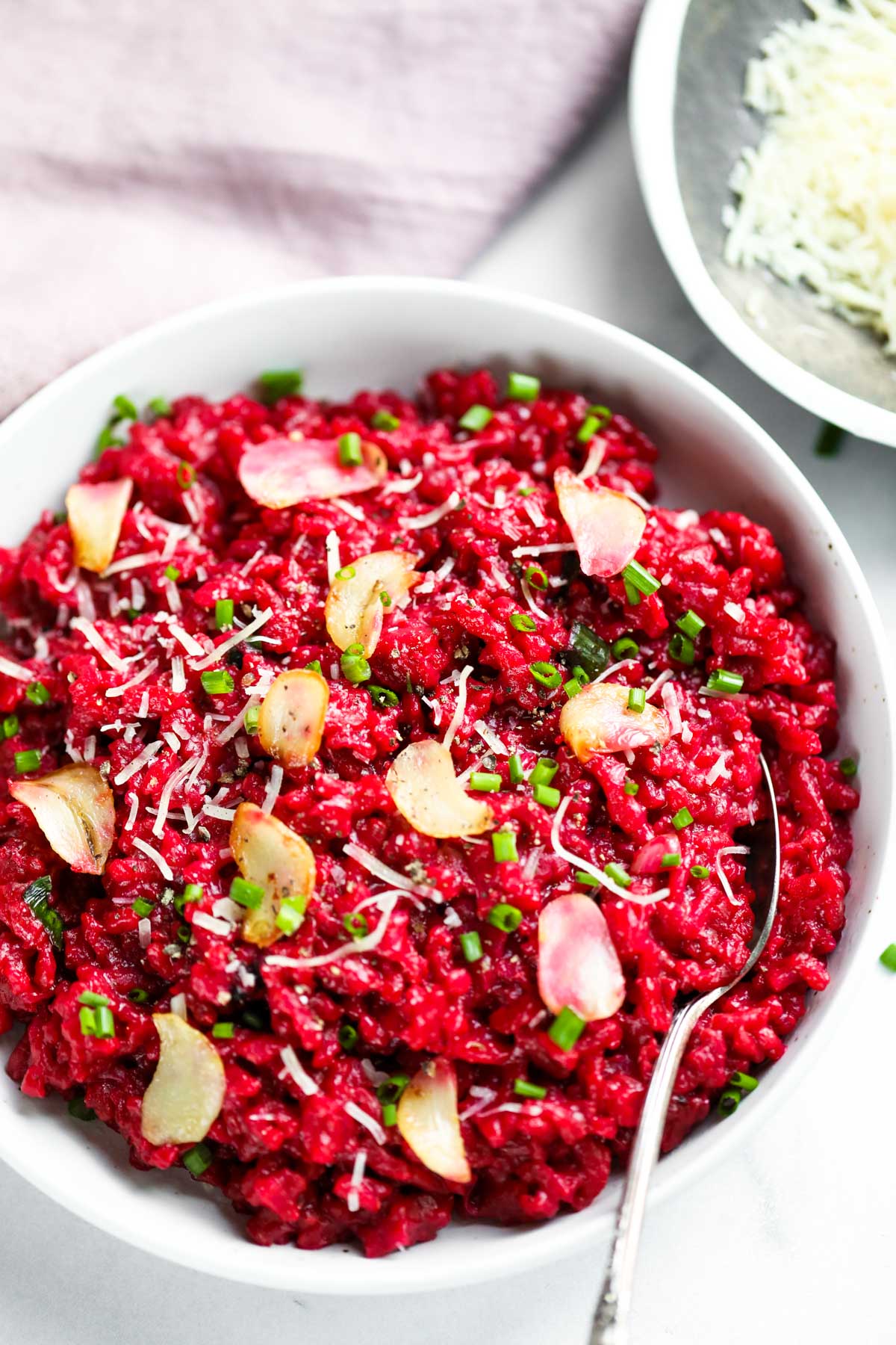 red wine and beetroot risotto in a white bowl 