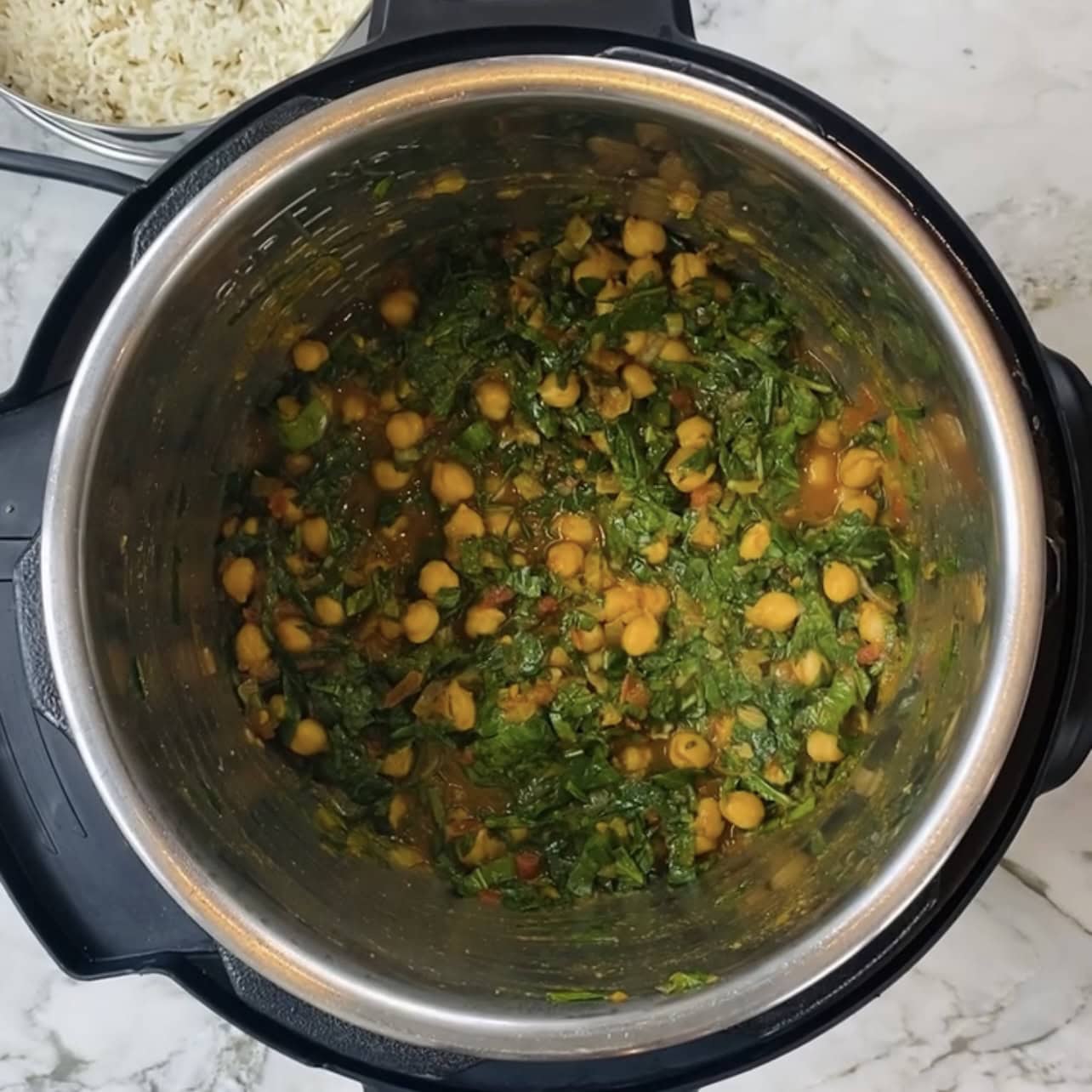A pot of food with rice and beans, similar to an Instant Pot chana saag, perfect for a hearty and flavorful meal.