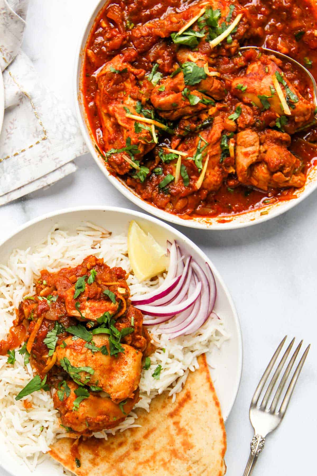 chicken kadai served over rice in a white bowl 