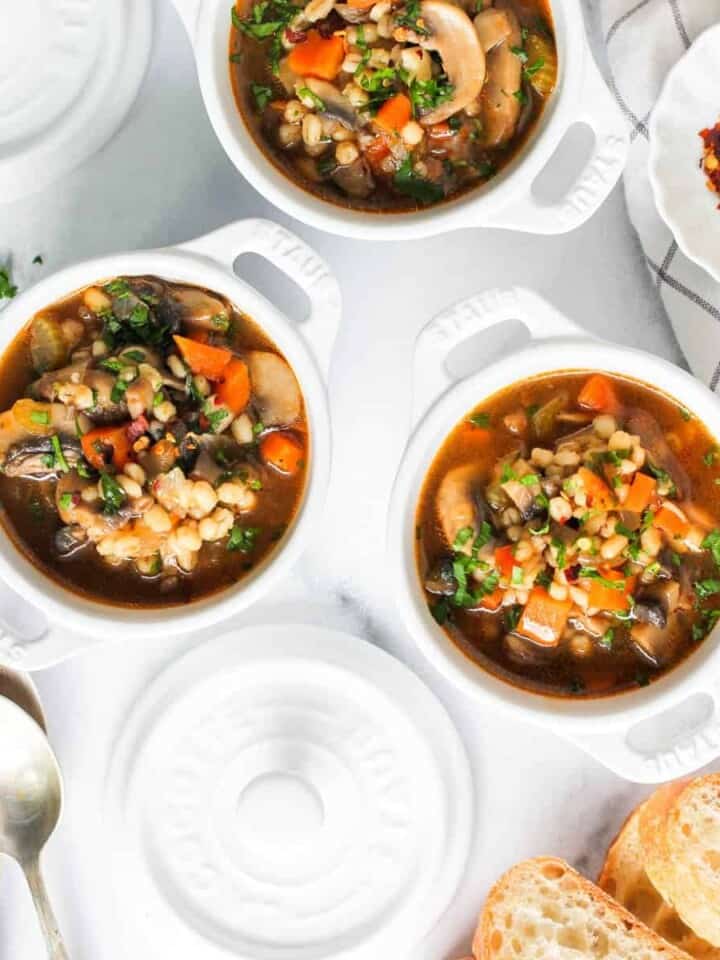 mushroom barley soup served in 3 white bowls