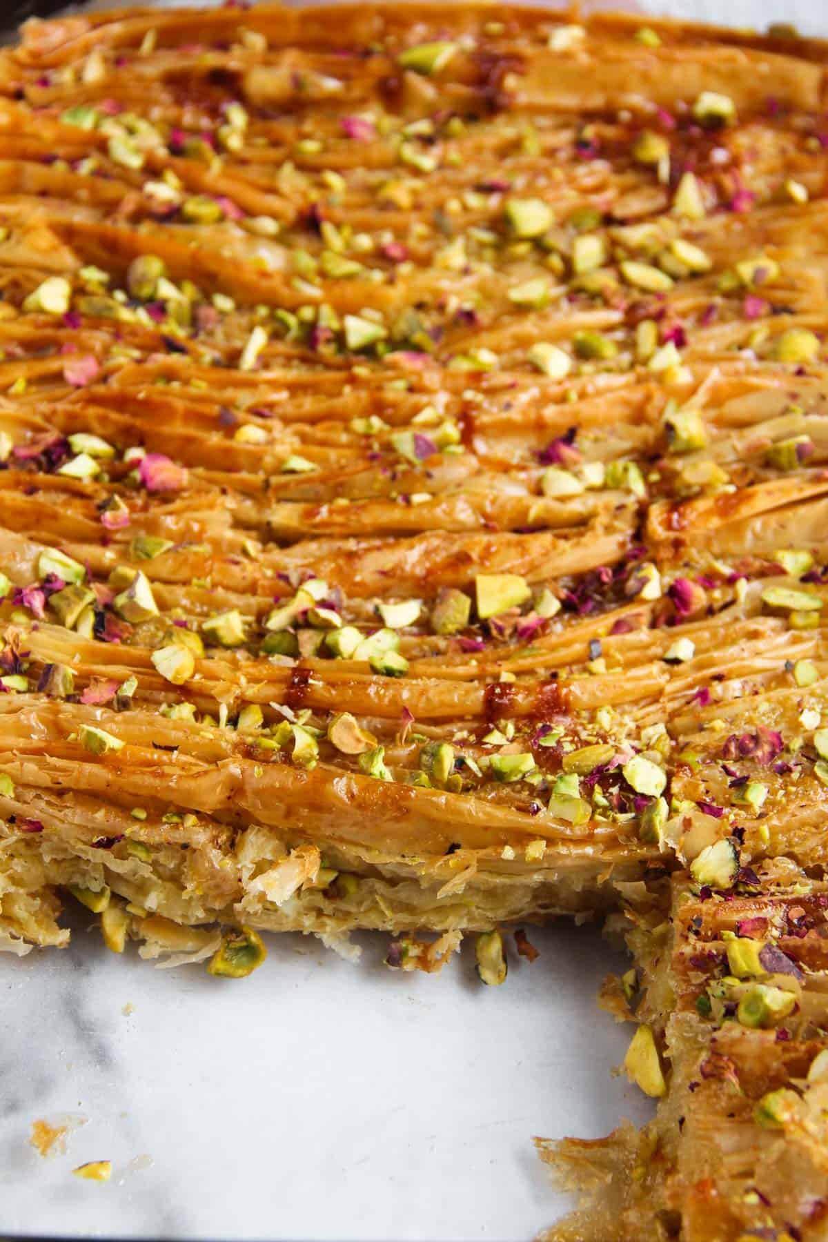 crinkle cake garnished with pistachios and rose petals 