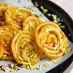 Jalebi garnished with pistachions and rose petals
