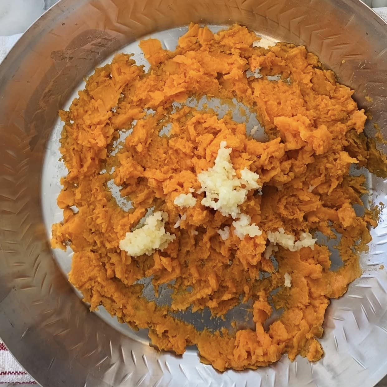 mashed sweet potatoes and garlic in a mixing bowl.