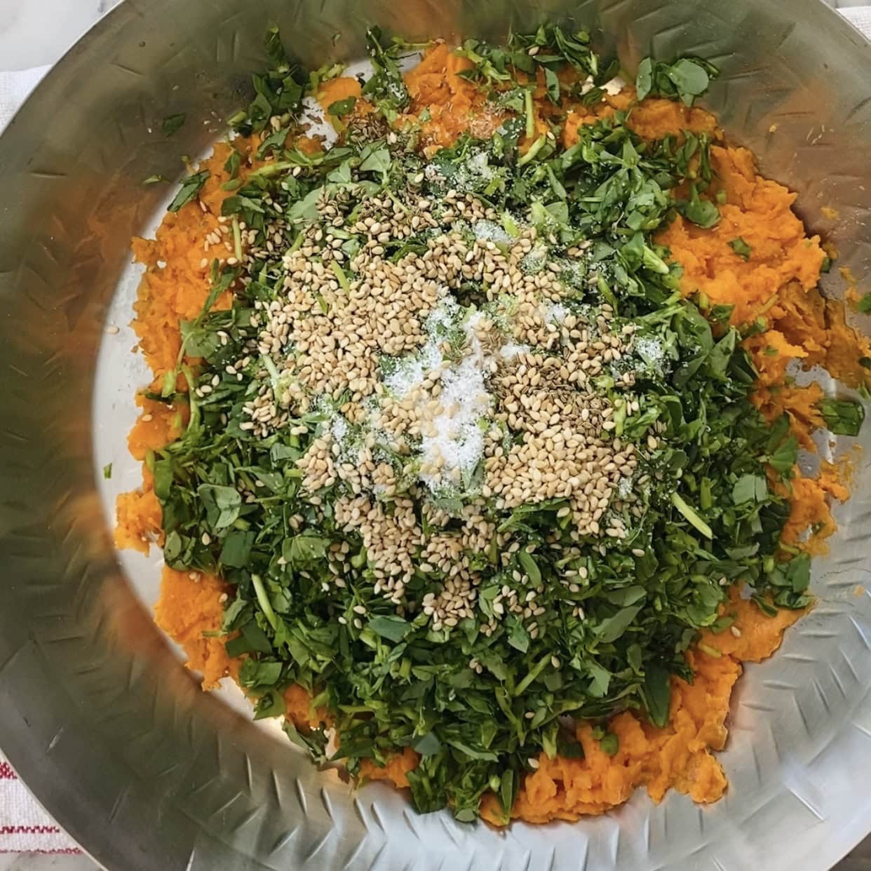 salt, carom seeds and sesame seeds added to the bowl. 