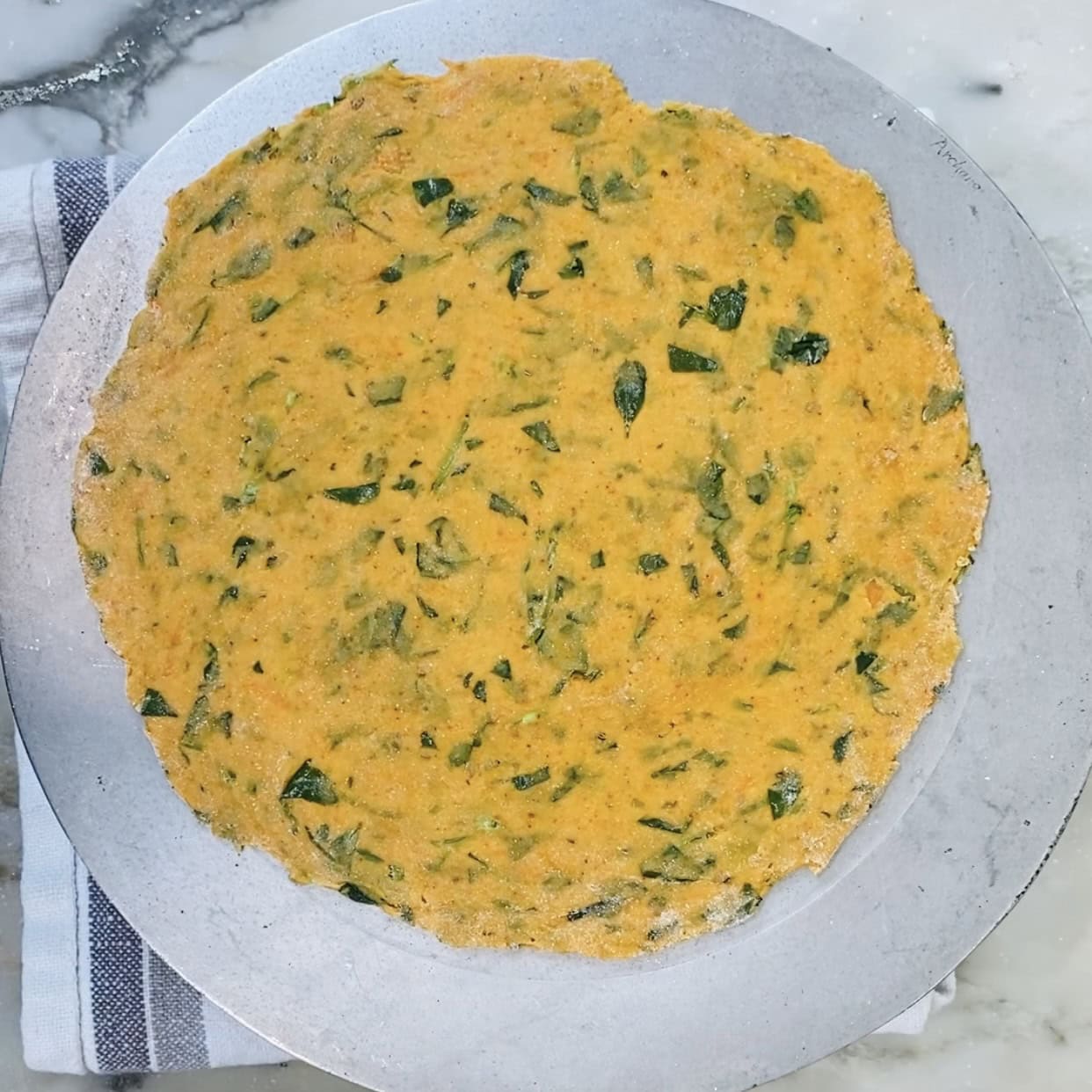 rolled methi thepla on a chakla.