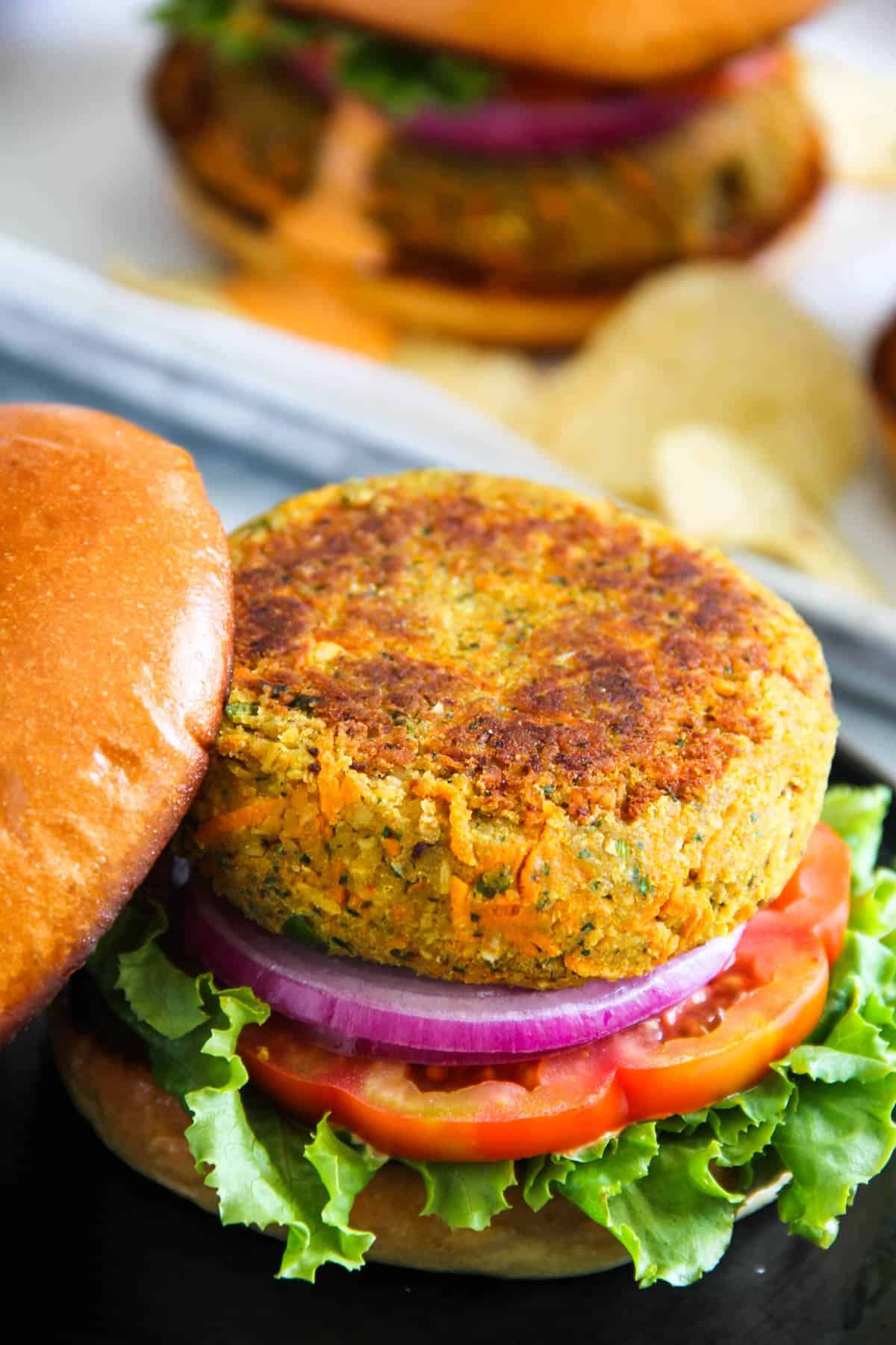 veggie Masala chickpea burger served on a bun with lettuce, tomato and onion