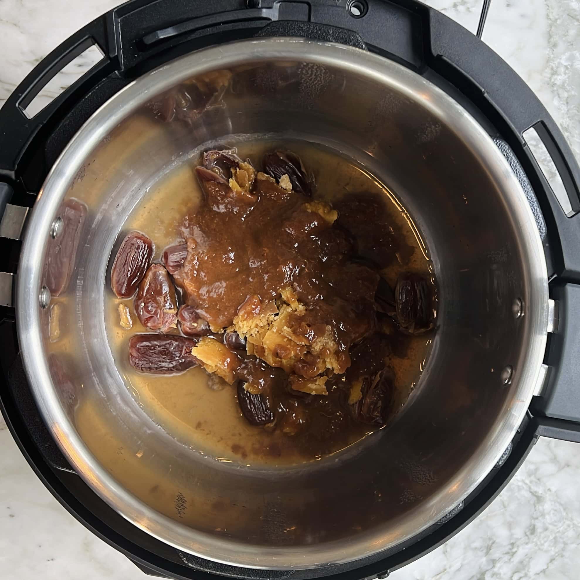 An overhead view of an Instant Pot containing pitted dates and a brown, paste-like mixture on the bottom.