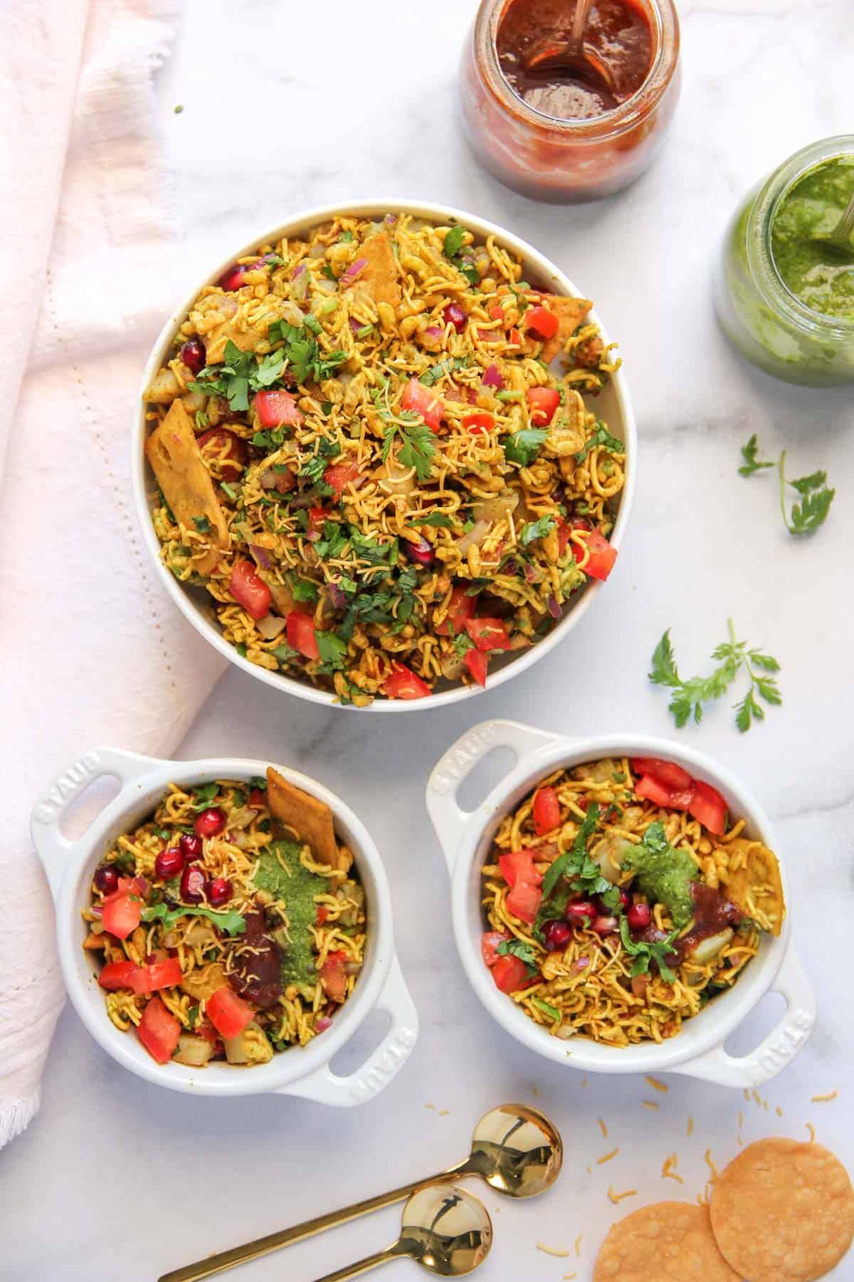 Bhel Puri in a serving bowl and two individual bowls 