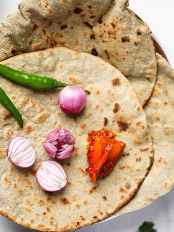 Bajra roti served with onion, green chili and Indian pickles