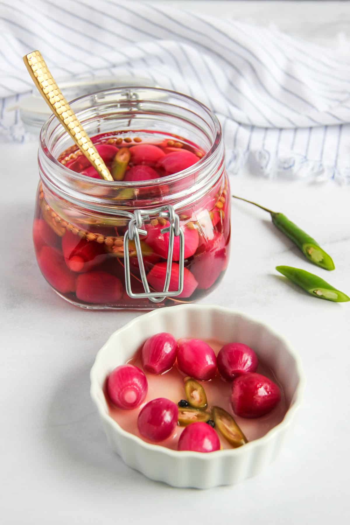 pickled pearl onions in a white plate and in a glass jar
