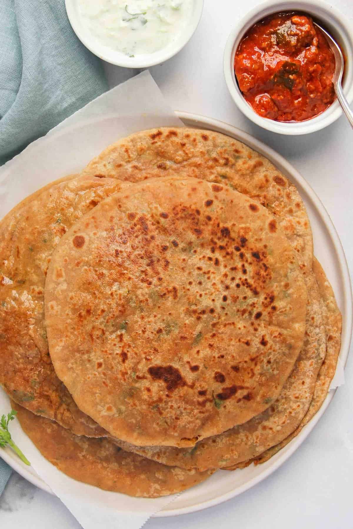 stack of Aloo Parathas in a white plate 