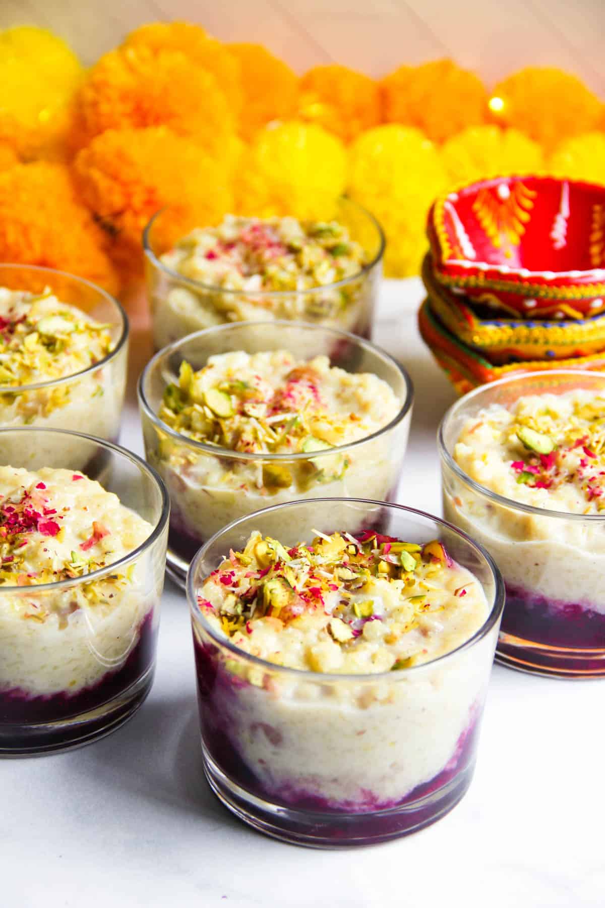 Rice pudding with berry compote garnished with pistachios and rose petals