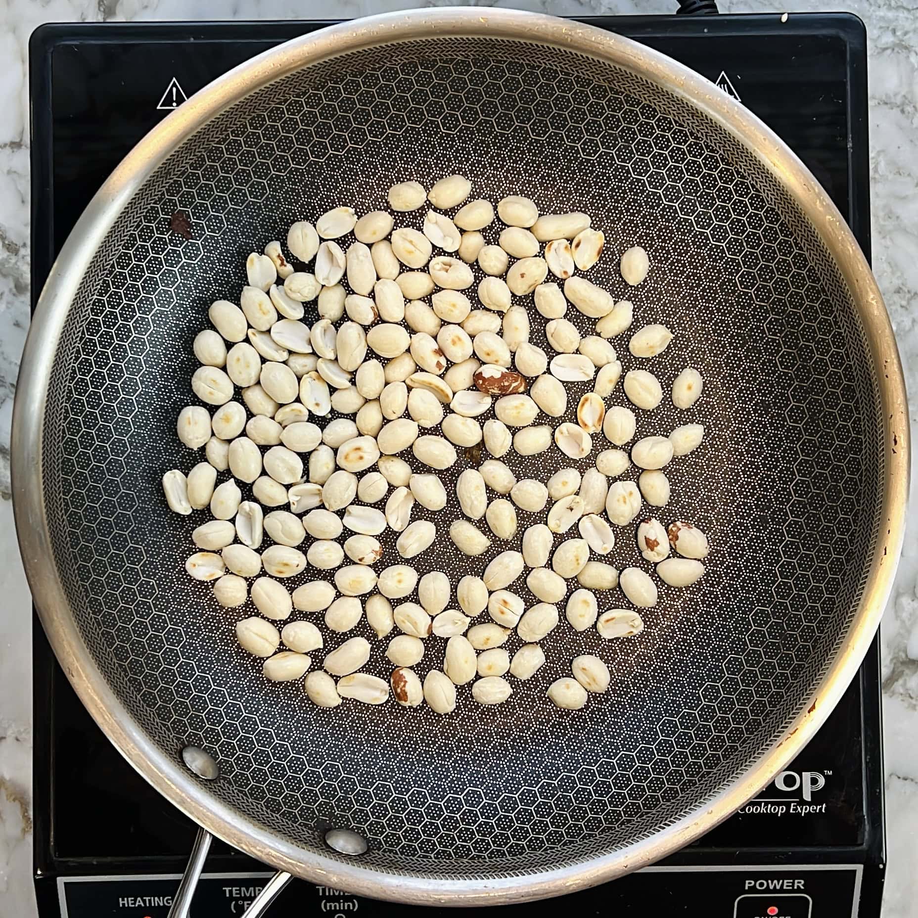 Roasting peanuts seeds in a pan.