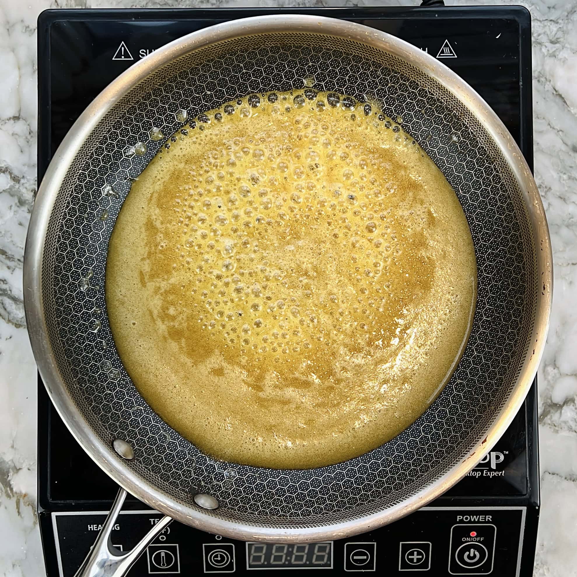 melted bubbly jaggery in a nonstick pan.