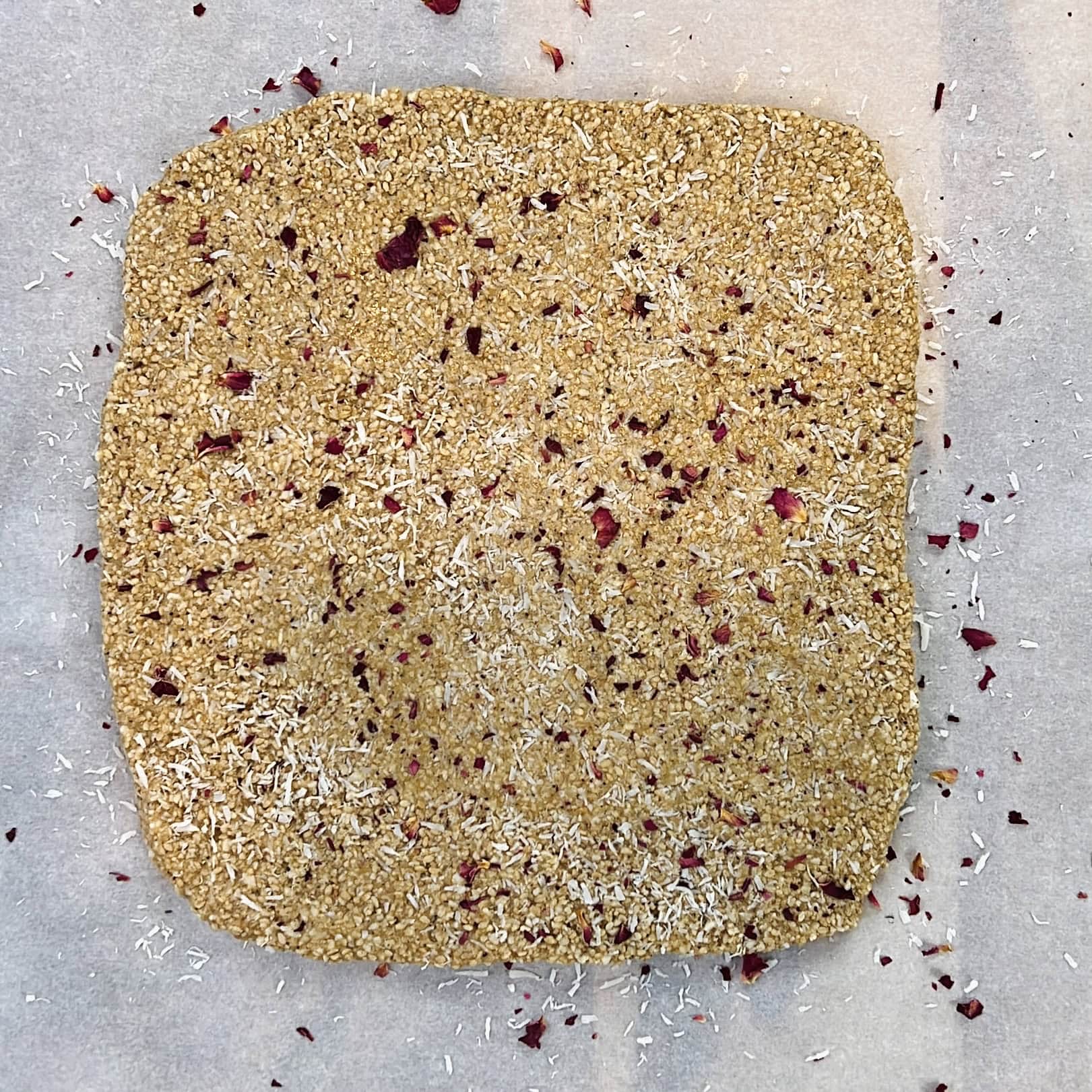 rolled tilachi vadi mixture garnished with coconut and rose petals.