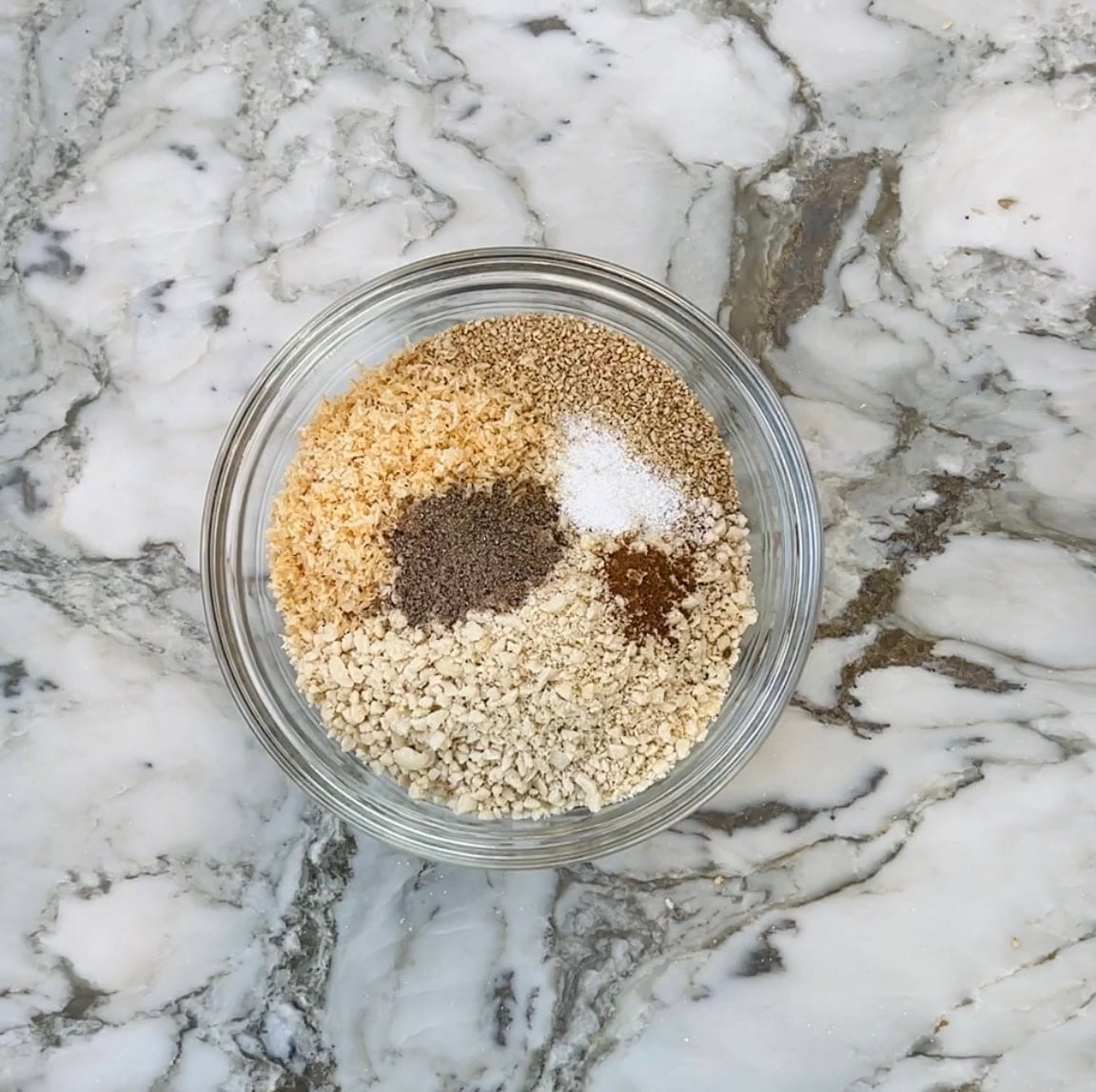 roasted ground sesame seeds, peanuts and coconut along with ground spices in a mixing bowl.
