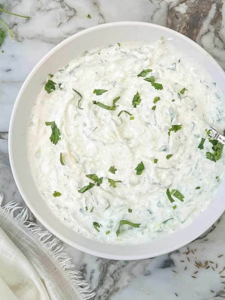 mint cucumber raita in a white bowl