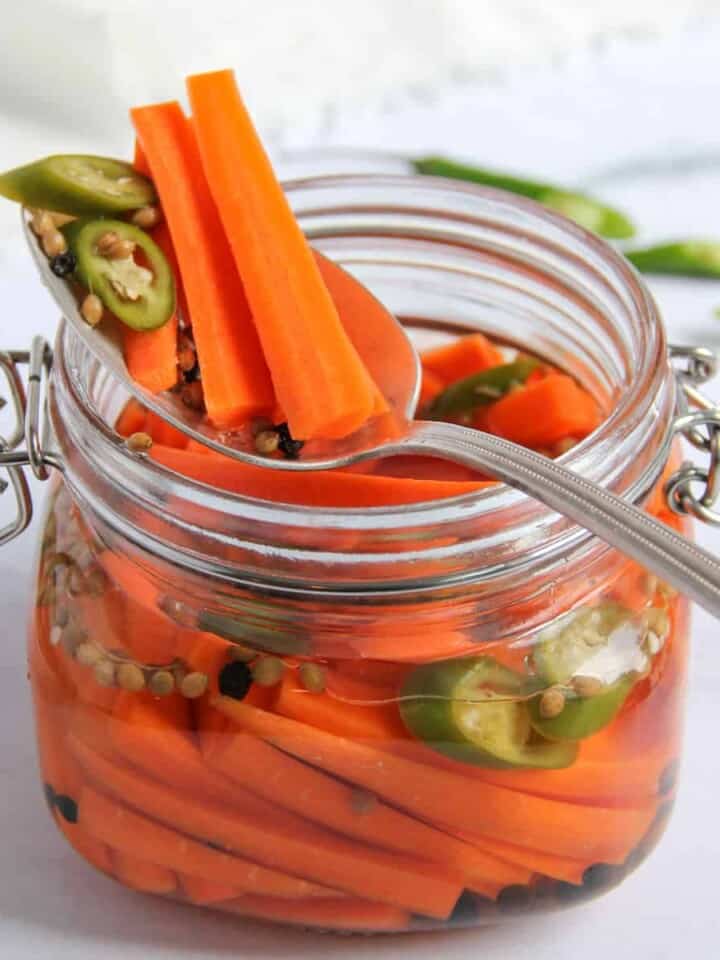 pickled carrots with green chilies in a glass jar