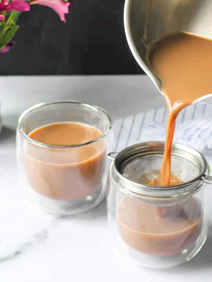 pouring ginger chai in two glass cups