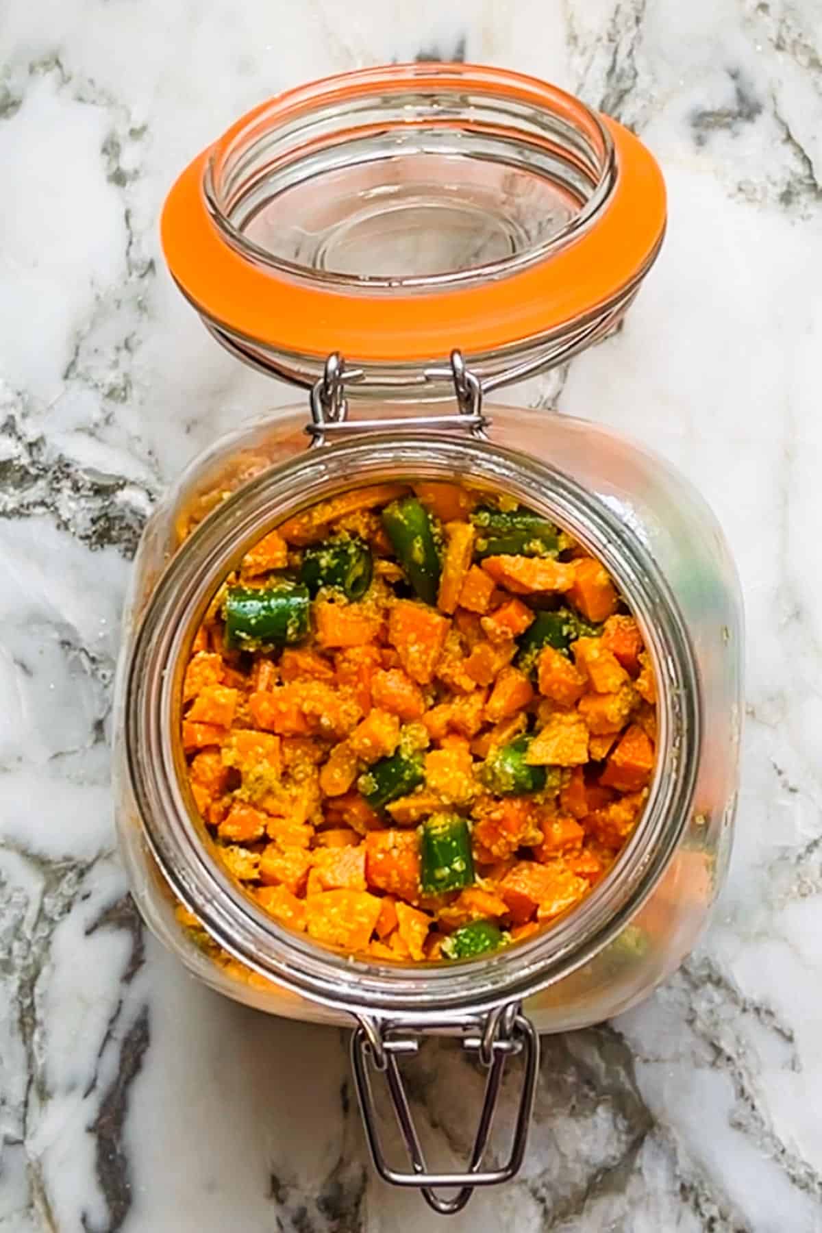 fresh turmeric pickle with green chilies  in a glass jar