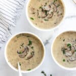 mushroom soup served in three white bowls
