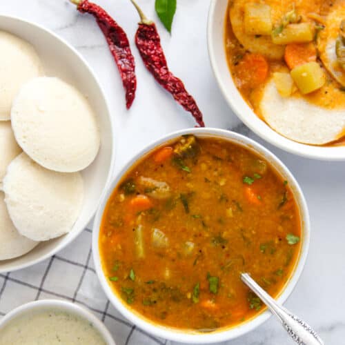 sambar served in a bowl alongside idli