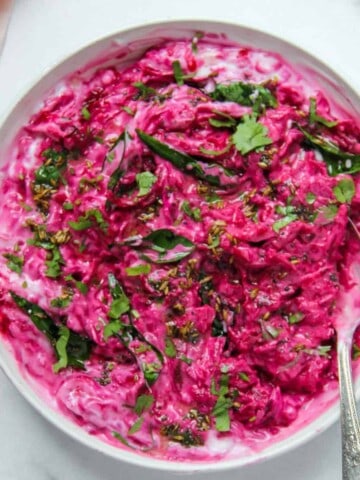 beet koshimbir in a white bowl garnished with cilantro and curry leaves