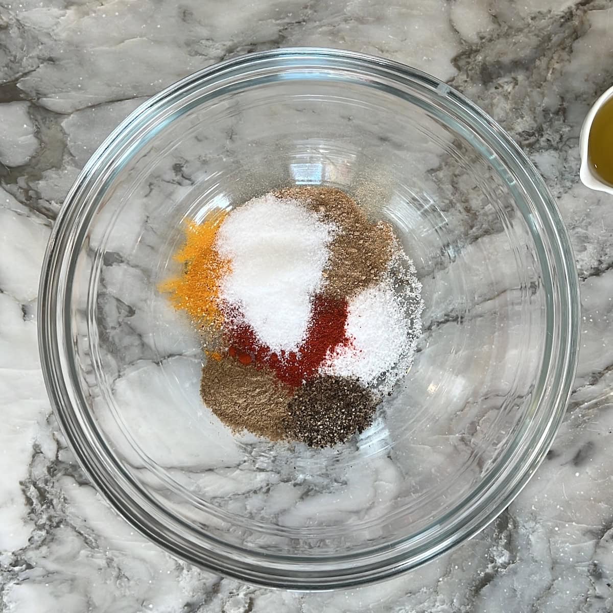 ground spices added to a glass bowl