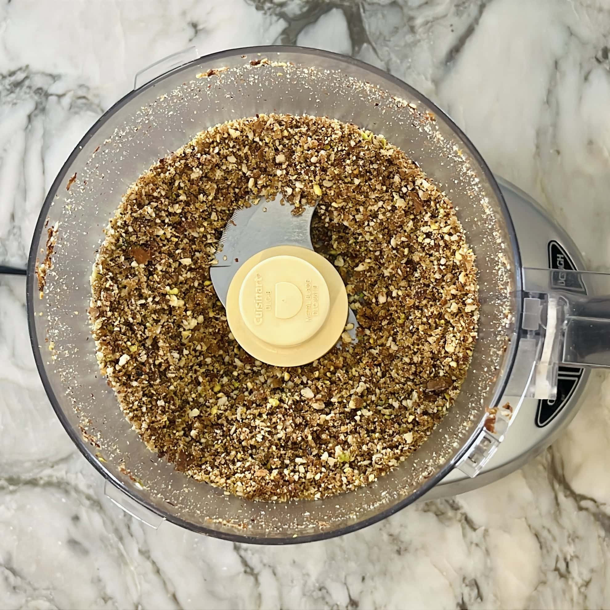 ground nuts and dates in food processor jar.