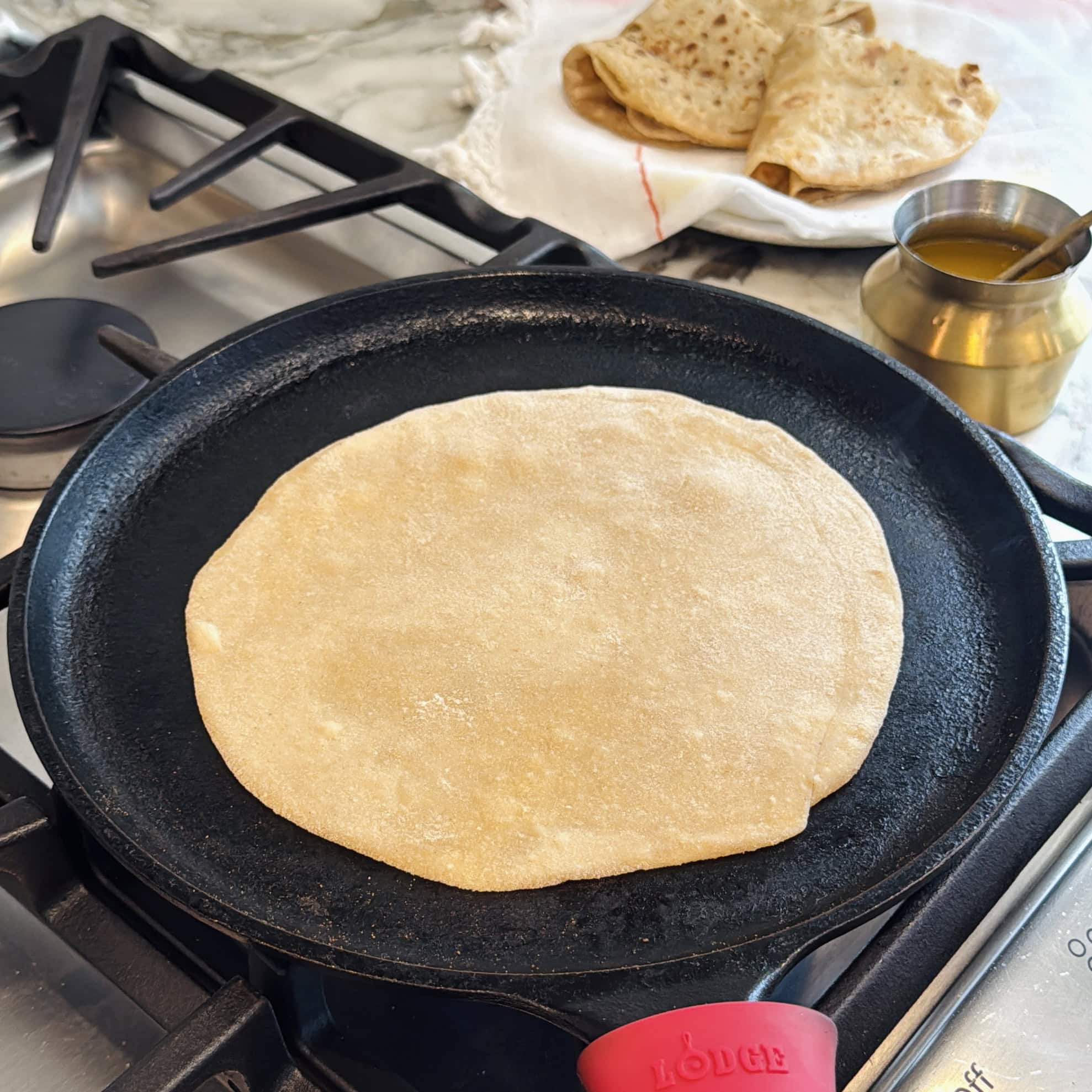 chapati on a cast iron pan with bubbles.