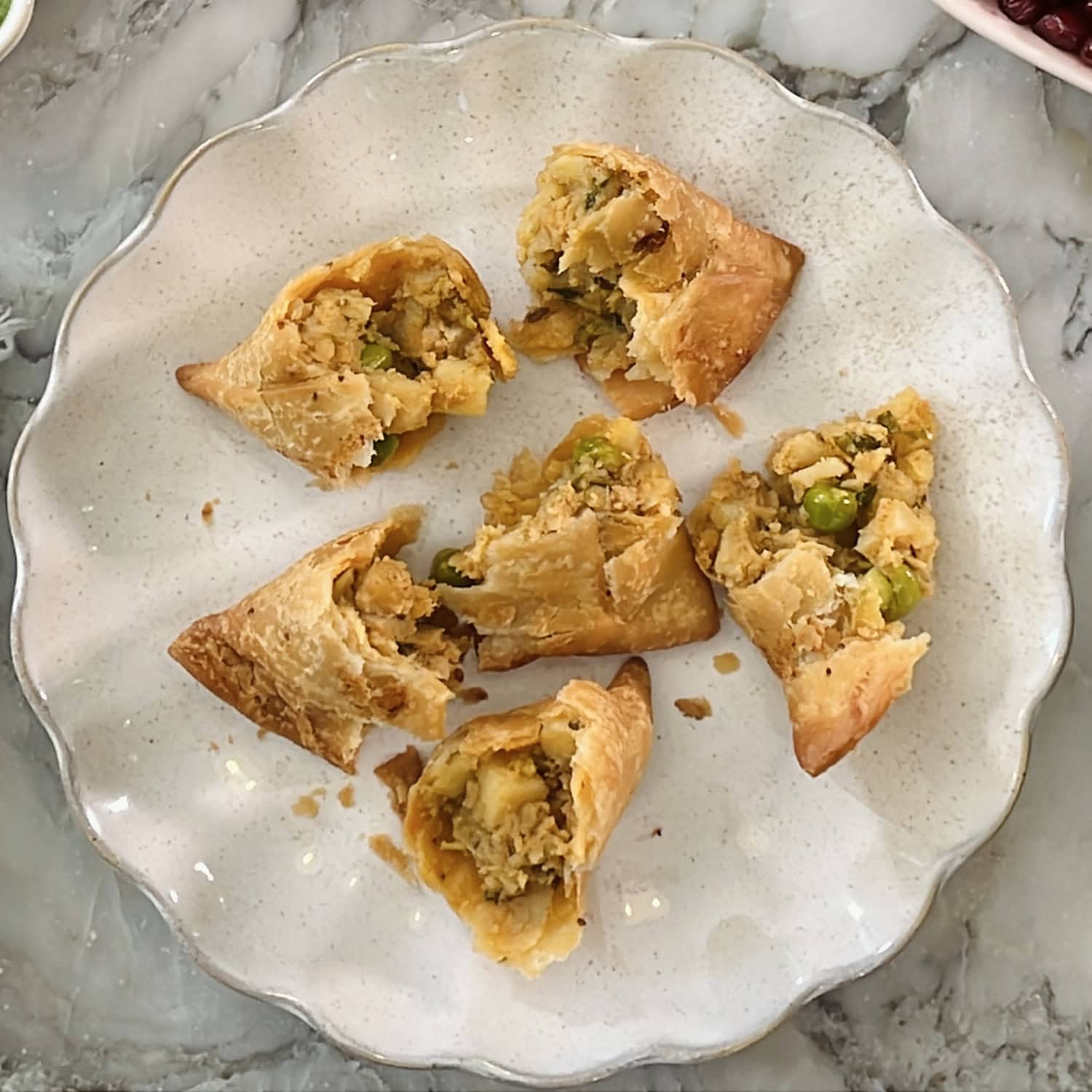 broken samosas in a serving plate.
