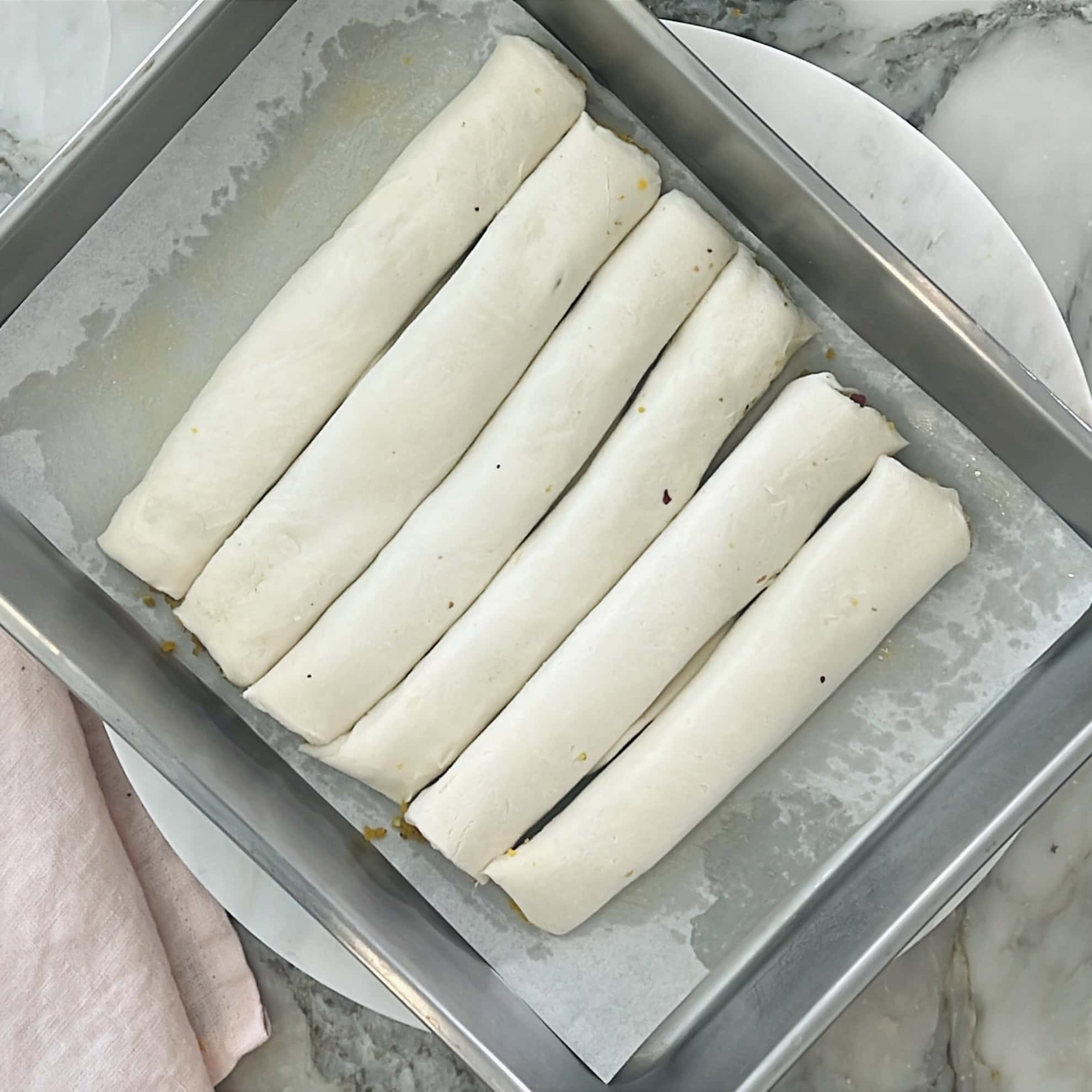 paratha rolls lines in a baking tray.