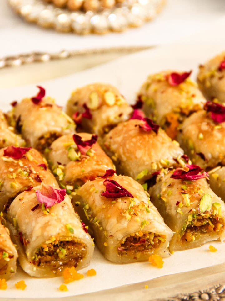 Motichoor pistachio pastry bites garnished with pistachios and dried rose petals in a silver tray