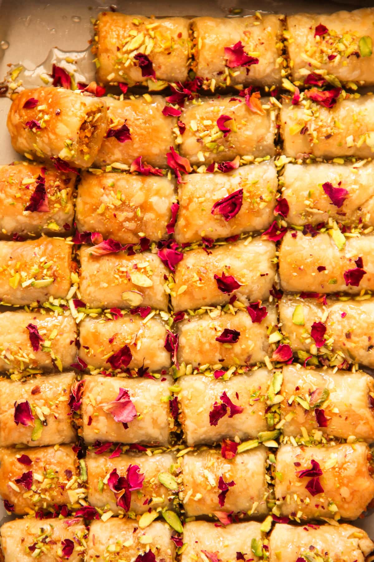 Motichoor pastry mithai bites garnished with pistachios and rose petals.