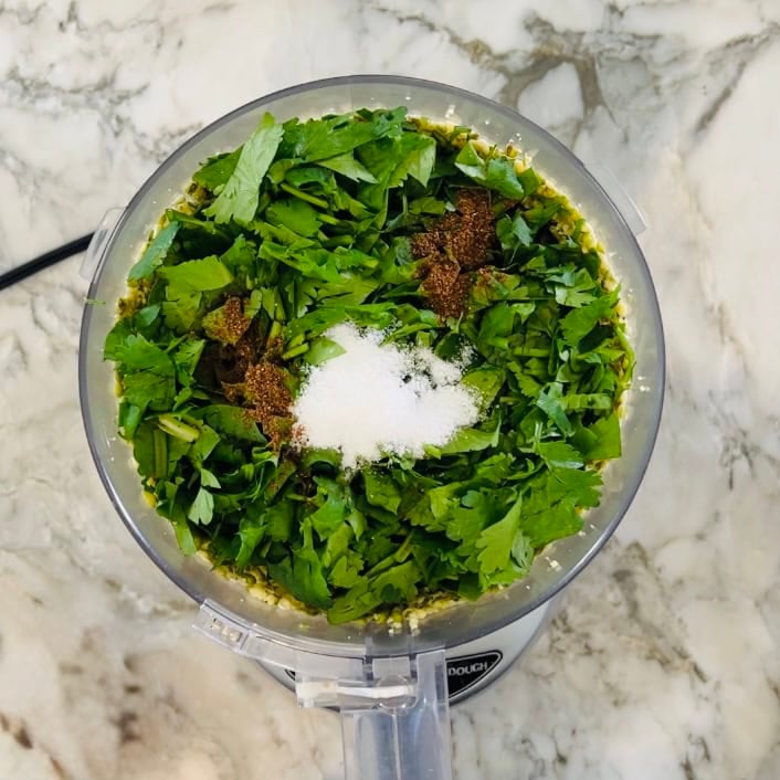 spinach, cilantro and spices added to food processor jar.